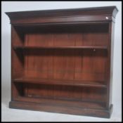 A Victorian mahogany open window library bookcase cabinet being raised on a plinth base with central