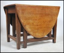 A late 19th century large solid oak Arts & Crafts drop leaf dining table being raised on squared