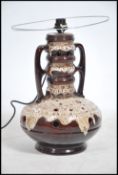 A German Fat Lava type Retro style lamp base, with brown, red glazes, and light fitting to the top