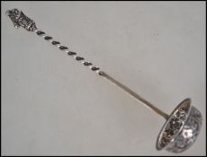 A silver hallmarked chocolate ladel of rococo form having spiral twist handle with apostle handle.