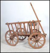 An unusual German country rustic pine hay cart raised on cartwheels with German Dresden metal plaque