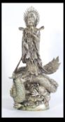 A silver plated large Chinese figurine of Guan-Yin, the Goddess of Compassion standing on a writhing