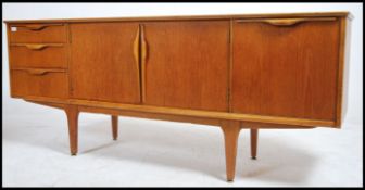 A 1970's retro Danish inspired teak wood sideboard dresser being raised on tapered supports having a