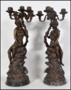 A pair of 20th century Empire style bronze candelabra, each modelled in the form of a semi clad