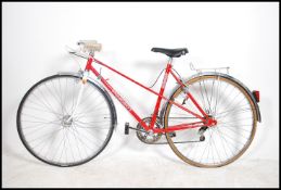 A stunning retro ladies bicycle by Peugeot, original red paint finish, drop handle bars and ten