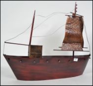 A 20th century tin plate model of a galleon ship with sails hoisted up. Measures 59cm high.