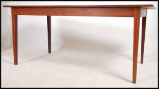 A large 1960's mid century Danish inspired rosewood dining table being raised on squared legs having