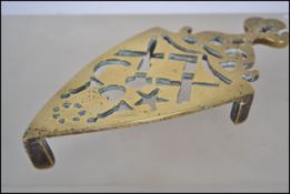 A 19th century Victorian cast brass trivet having pierced masonic symbols being raised on sqaured