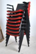 A set of eight retro 20th century stacking chairs with ebonised tubular frames and armrests, the