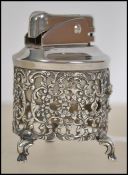 A silver 850 cased table lighter of cylindrical rococo form being raised on hoof feet. Total