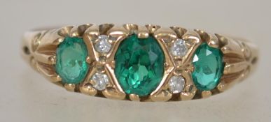 A vintage 9ct gold diamond and emerald ladies. The 3 oval cut emeralds interspersed with diamonds.