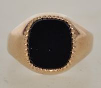 A 9ct hallmarked gold and agate set gentlemans signet ring. Total weight 4.1g / Size T.5