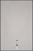 A ladies silver and opal pendant necklace. The teardrop shaped pendant being set to a fine linked