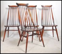 A set of 4 Ercol 20th century beech and elm wood quaker dining chairs being raised on turned legs