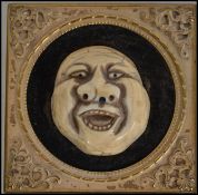 A 19th century gilt framed Laughing ivory Buddha mask. The ivory mask mounted on a velvet border.
