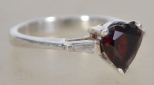 A stunning 14ct white fold and garnet stone ring in the form of a heart being facet cut and claw