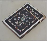 A 19th century tortoiseshell and mother-of-pearl foliate inlaid card case. Measures 10cm high.