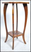 An early 20th century mahogany plant stand - bust stand having sabre style legs with twin tiers, the