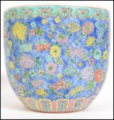 A Chinese famille rose cylinder shaped planter having a pastel blue ground with foliate decoration