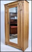 An Edwardian Arts  & Crafts solid oak single wardrobe having central mirror door with beautiful