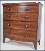 A 19th century Georgian mahogany bow front chest of drawers being raised on French kick feet