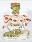 A Victorian Staffordshire ceramic spill vase flat back. The figurine diorama depicting a cow and