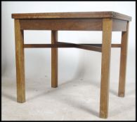 A mid century Air Ministry oak occasional dining table of square form raised on squared legs with