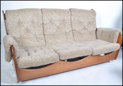 A Kofod Larsen for G-Plan vintage 20th century retro teak framed three seat ' saddle ' sofa having
