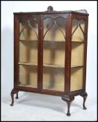 A 1930's mahogany Queen anne display cabinet raised on cabriole legs having central door with
