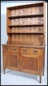 A 1920's oak dresser being raised on turned supports having a series of cupboards and drawers with