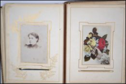 A Victorian leather bound photograph album embossed with floras and carnations.  This collection