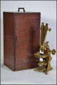 A  late 19th Victorian / early 20th Century mahogany cased gilt brass binocular microscope by