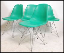 A collection of 4 Eames style DSW dining chairs. The dining chairs having green seat pads. All