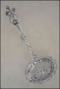 A 19th century very unusual tea strainer of large pierced form having winged Dodo handle over urn