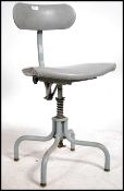 A mid century Industrial office swivel chair raised on a tubular metal frame with grey vinyl