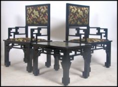 A pair of 20th century Chinese ebonised armchairs having lattice worked back rests over pad seats