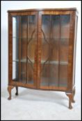 A 1930's walnut queen anne display cabinet being raised on cabriole legs with glass cabinet having
