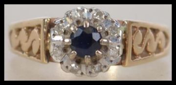 A hallmarked 9ct gold ladies sapphire and diamond ring having a central sapphire with a halo of