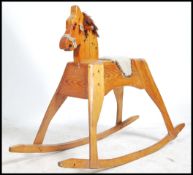 A vintage pine childs wooden rocking horse raised on sleigh runners with tassled main and saddle