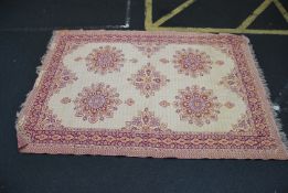 An Iranian handwoven rug of geometric form in a yellow and red ground with geometric panels having