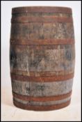 A full sized vintage 20th century oak coopered barrel having cast iron banding. Remains of paintwork