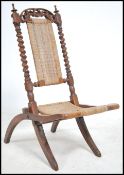A Victorian mahogany cane upholstered folding campaign chair having rattan weave seat and back