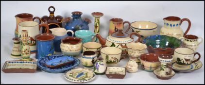 A large collection of Devon / Cornish torquay ware / mottoware ceramic pottery jugs and other