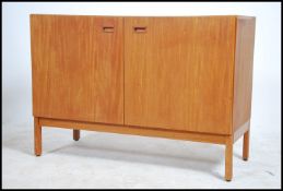 A 1970's teak wood  Danish influence twin door sideboard. Raised on angular block supports with twin