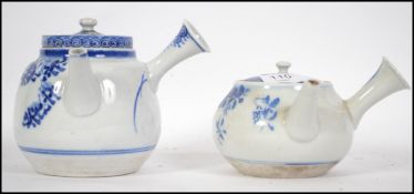 Two early 20th century Chinese blue and white ceramic teapots. Each with side handles and