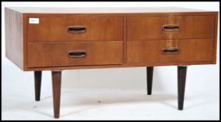 A 1970's retro Danish inspired teak wood low sideboard cabinet raised on tapered legs with a