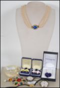 A collection of costume jewellery to include; A faux pearl triple corded necklace with blue cut