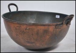 A large 19th Century copper cooking pot with twin iron handles having a bowl finish. Measures 32cm