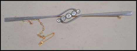 A beautiful 15ct gold, platinum and diamond ladies bar brooch with 9ct safety chain. Inset 5
