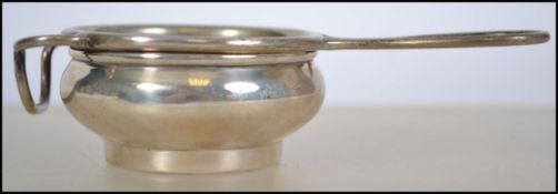 A silver hallmarked tea strainer and cup bearing hallmarks for WJ Myatt & Co, Birmingham 1934. Total